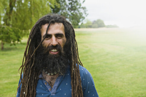 Ein Mann mit langen Dreadlocks und einem blauen Hemd. - MINF04803