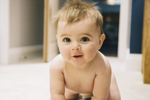 A young baby crawling on a rug. - MINF04818