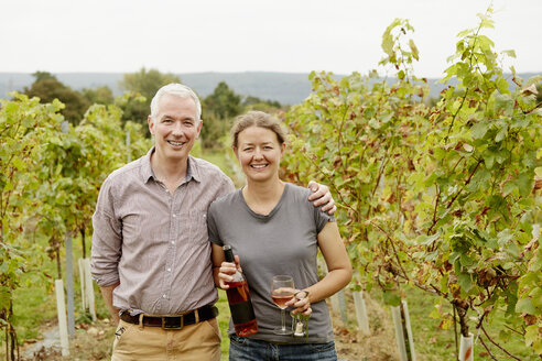 Ein Ehepaar, die Gründerin des Weinbergs und ihr Partner, stehen inmitten der Rebzeilen. - MINF04861