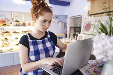 Junge Frau arbeitet in einem Café mit Laptop - ABIF00822