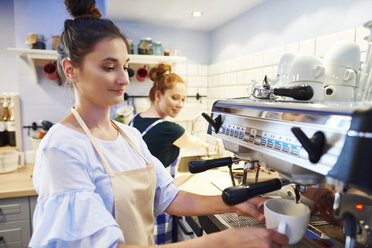Female barista making coffee at a cafe - ABIF00848