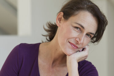 Portrait of woman wearing purple top, hand on chin - CUF43792