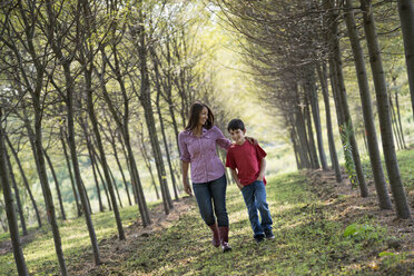Eine Frau und ein Kind gehen durch eine Baumallee. - MINF04973