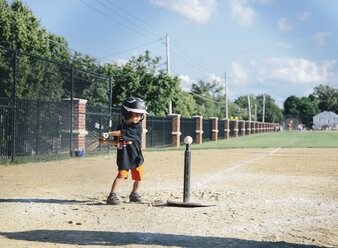 A child, boy swinging a baseball bat at practice on a baseball field. - MINF05054