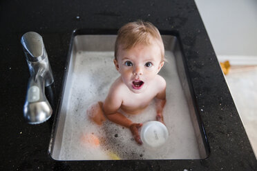 Ein kleines Mädchen, das in einem Waschbecken badet. - MINF05057