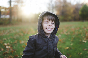 Ein Kind, ein Junge, der im Park spielt, umgeben von Herbstblättern. - MINF05063