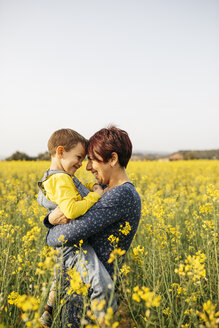 Mother standing with her little son in a rape field - JRFF01793