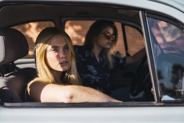 Portrait of young woman sitting in a car with friend - KKAF01349