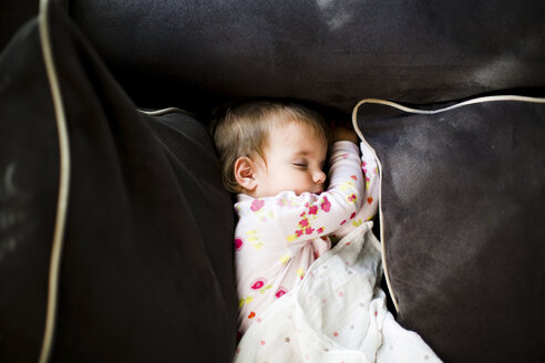 Ein kleines Mädchen, das auf den Kissen eines Sofas schläft. - MINF05090