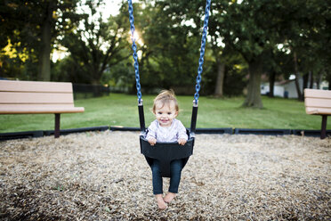 Baby girl sitting in a swing. - MINF05123