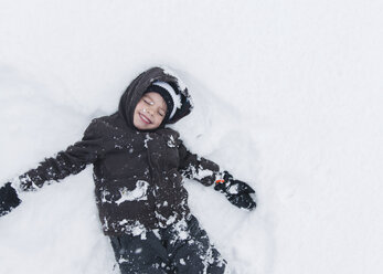 Boy, child lying and playing in snow. - MINF05127