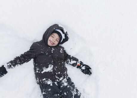 Junge, Kind liegend und spielend im Schnee. - MINF05127