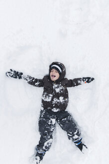 Junge, Kind liegend und spielend im Schnee. - MINF05128