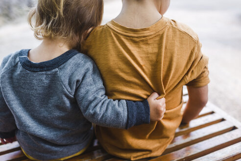 Boy, child and toddler girl sitting on a bench and hugging. - MINF05134