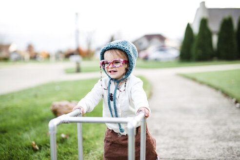 A toddler, girl wearing a Halloween costume of an elderly woman in a suburban neighbourhood. - MINF05149
