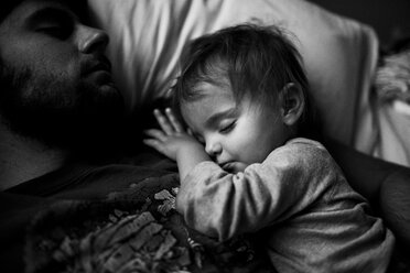 Vater und kleines Mädchen kuscheln, schlafen auf einem Bett. - MINF05263