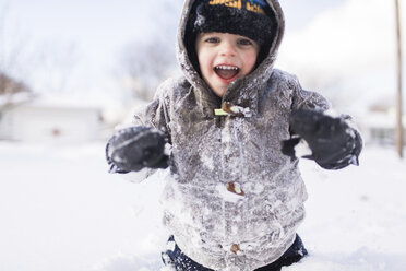 Boy, child wearing a coat and standing in the snow. - MINF05269