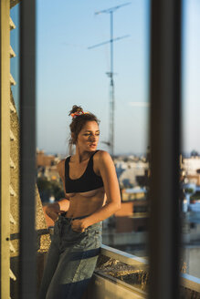 Junge Frau mit BH auf dem Balkon stehend - KKAF01429