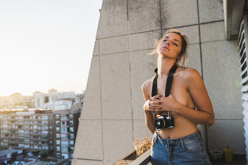 Topless junge Frau mit Kamera auf Balkon stehend - KKAF01433