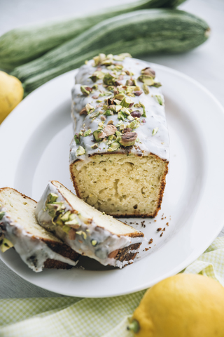 Zitronen-Zucchinikuchen mit Zitronenglasur und Pistazienbelag, lizenzfreies Stockfoto