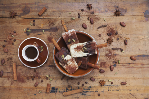 Hausgemachte Espresso und weiße Schokolade Eis Lutscher mit Winter Gewürze und Tasse Espresso auf hölzernen Hintergrund, lizenzfreies Stockfoto