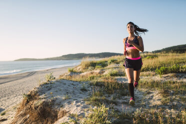 Young sportswoman training on the coast, jogging - RAEF02064