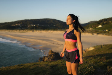 Sportliche Frau genießt das Licht des Sonnenuntergangs - RAEF02065