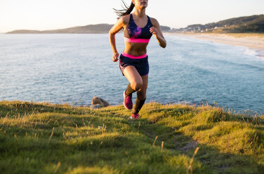 Woman running in a coastal landscape - RAEF02069