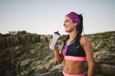 Portrait of an athlete woman drinking water outdoors - RAEF02074