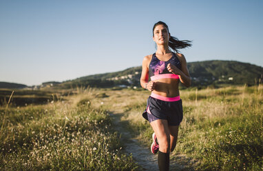 Sportlerin joggt auf einem Weg - RAEF02098