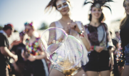 Feiernde auf einem Sommermusikfestival, große Seifenblasen im Vordergrund. - MINF05559