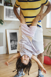 Familienhaus: Ein Mann spielt mit seiner Tochter, die er auf dem Kopf hält. - MINF05675