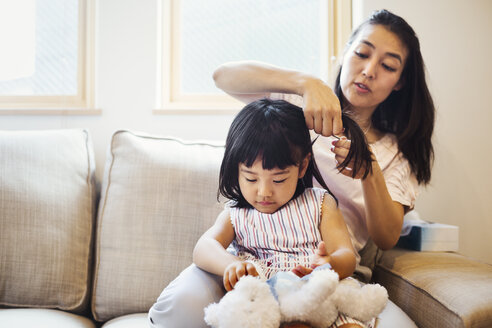 Familienhaus: Eine Mutter kämmt ihrer Tochter die Haare. - MINF05687