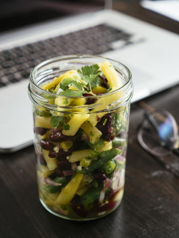 Jar of three bean salad on office desk stock photo