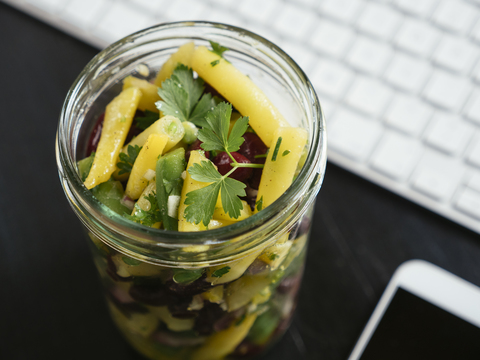 Jar of three bean salad on office desk stock photo