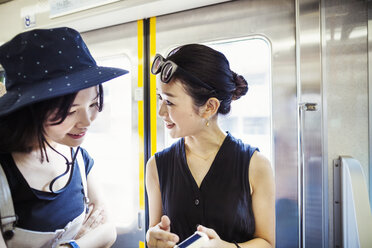 Zwei junge Frauen, die in einem Zug reisen. - MINF05703
