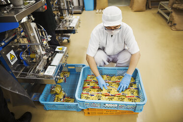 Arbeiter in einer Fabrik, die Soba-Nudeln herstellt, verpackt frische Nudeln für den Vertrieb und den Verkauf. - MINF05740