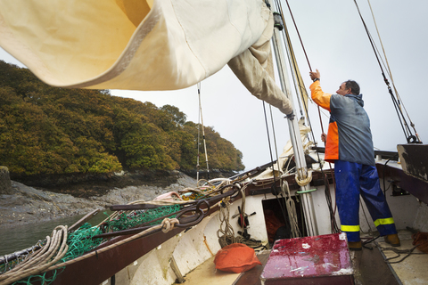 Traditionelle nachhaltige Austernfischerei: Ein Fischer auf einem Segelboot., lizenzfreies Stockfoto