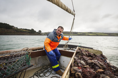 Traditionelle nachhaltige Austernfischerei: Ein Fischer auf einem Segelboot sortiert den Austernfang - MINF05810