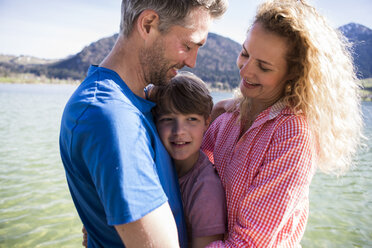 Österreich, Tirol, Walchsee, glückliche Eltern mit Sohn eng zusammen am See - JLOF00172