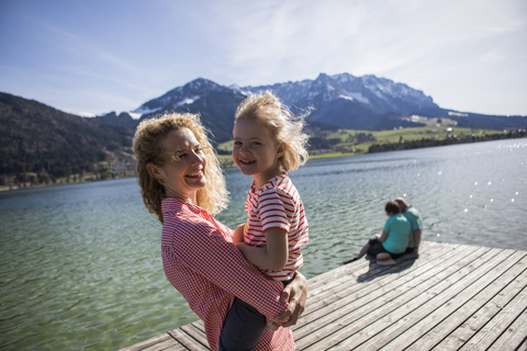 Österreich, Tirol, Walchsee, glückliche Mutter mit Tochter am See, lizenzfreies Stockfoto