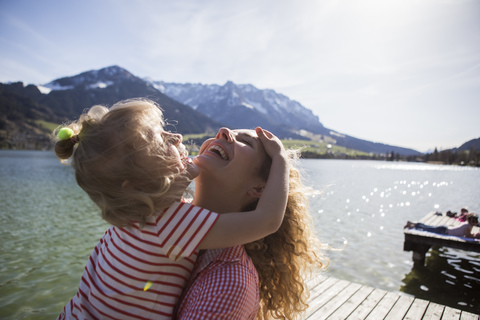 Österreich, Tirol, Walchsee, glückliche Mutter mit Tochter am See, lizenzfreies Stockfoto
