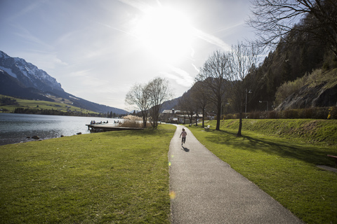 Österreich, Tirol, Walchsee, Mädchen läuft auf Weg am See, lizenzfreies Stockfoto