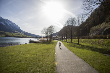 Österreich, Tirol, Walchsee, Mädchen läuft auf Weg am See - JLOF00190