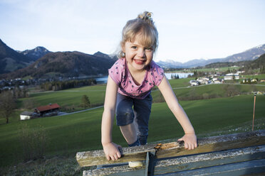 Austria, Tyrol, Walchsee, happy girl on a bench - JLOF00212