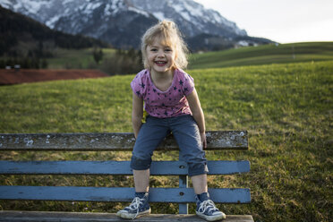 Austria, Tyrol, Walchsee, happy girl on a bench - JLOF00213