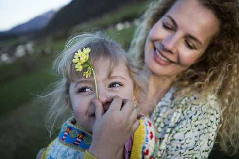 Glückliche Mutter und Tochter mit Blumen auf einer Wiese - JLOF00214