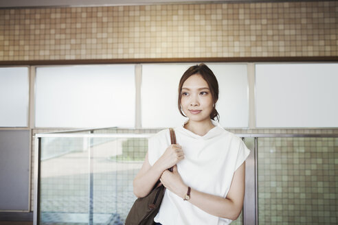 Lächelnde junge Frau in einer U-Bahn, eine Tokioter Pendlerin. - MINF06000