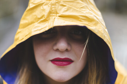 Porträt einer Frau mit gelber Kapuze einer Regenjacke - AFVF01282