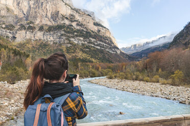 Spanien, Ordesa y Monte Perdido National Park, Rückenansicht einer Frau mit Rucksack beim Fotografieren - AFVF01291